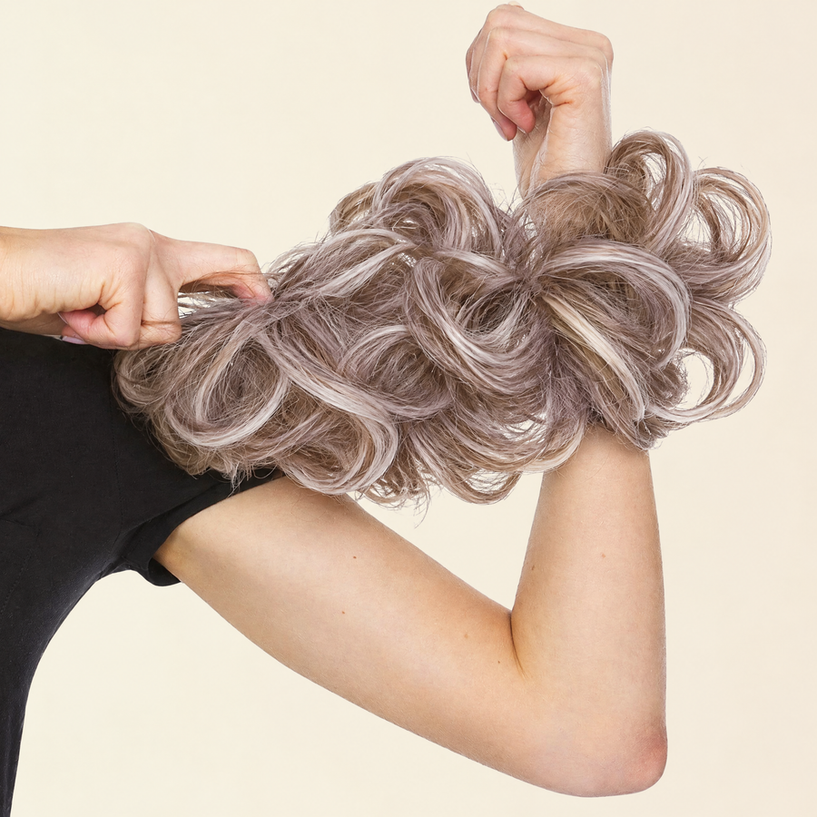 Hands stretching the JuvaBun Messy Bun in Beach Blonde to show the scrunchie band