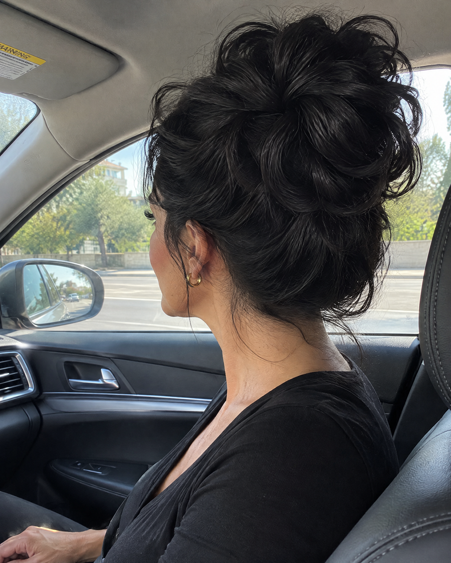Woman wearing the JuvaBun Messy Bun in Black in the car