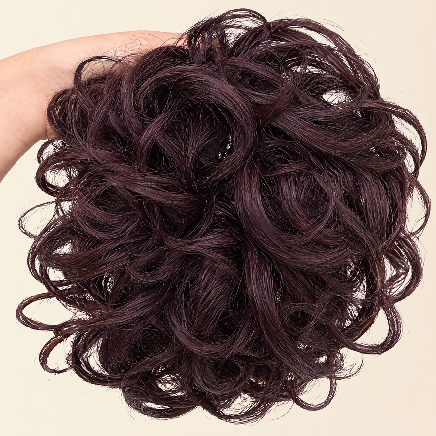 Hand holding the full JuvaBun Messy Bun in Dark Brown
