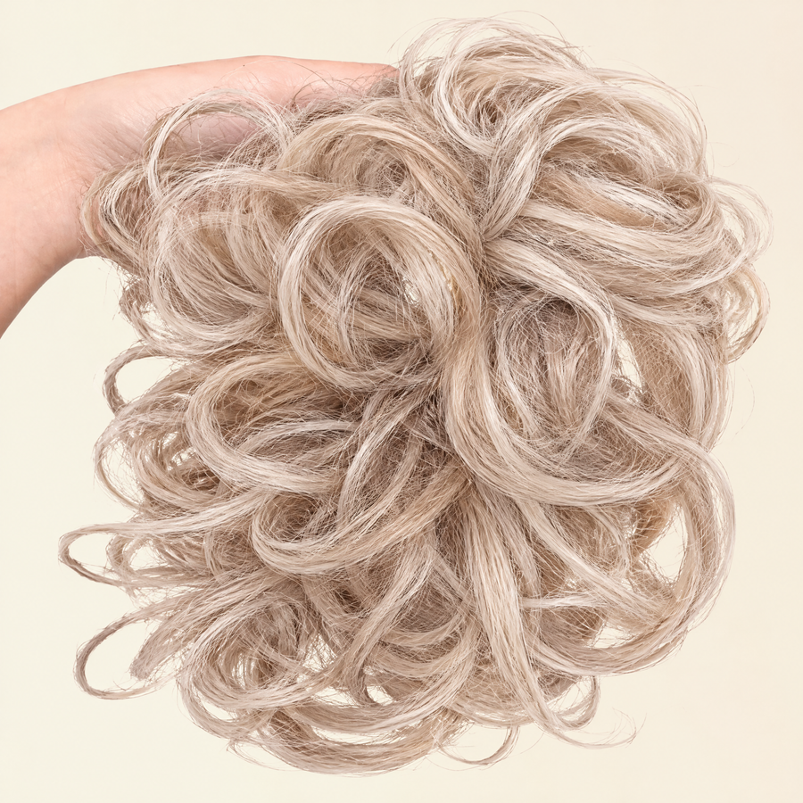 Hand holding the full JuvaBun Messy Bun in Light Brownish Blonde