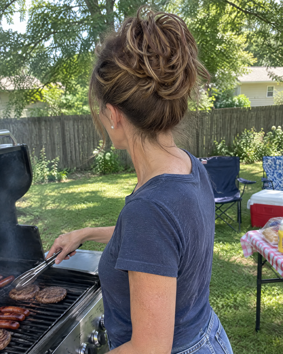 Woman wearing the JuvaBun Messy Bun in Mix Walnut at a backyard barbecue