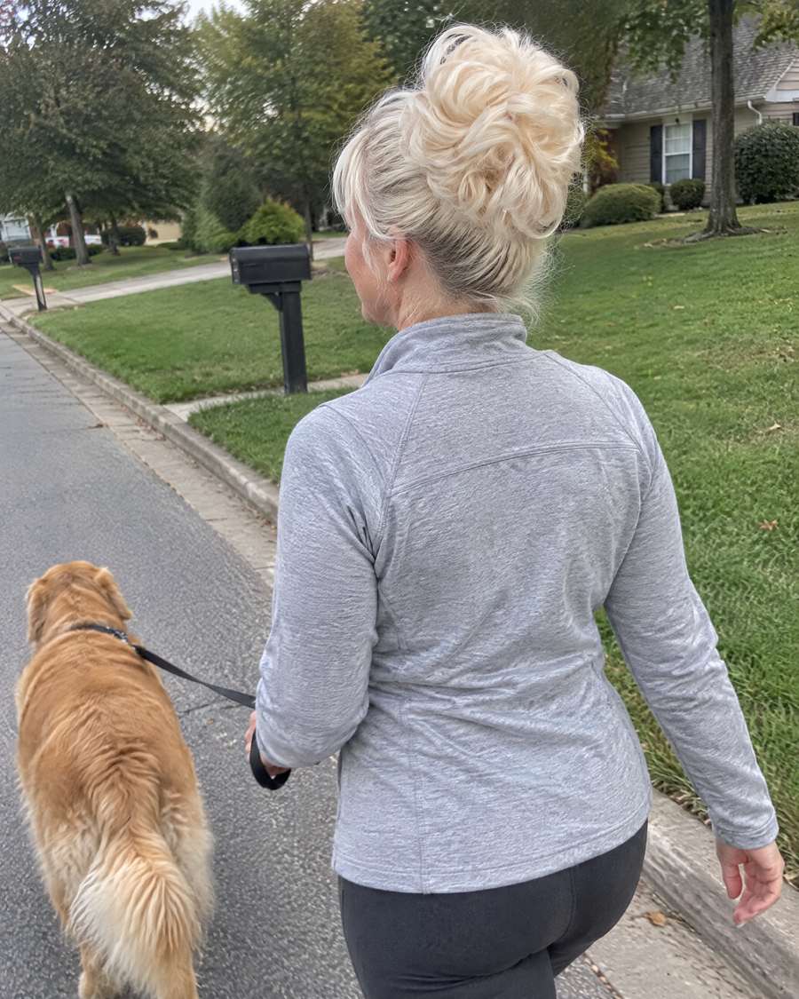 Woman wearing the JuvaBun Messy Bun in Platinum Blonde walking her dog