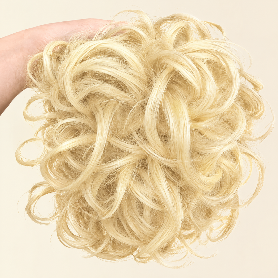 Hand holding the full JuvaBun Messy Bun in Pure Blonde