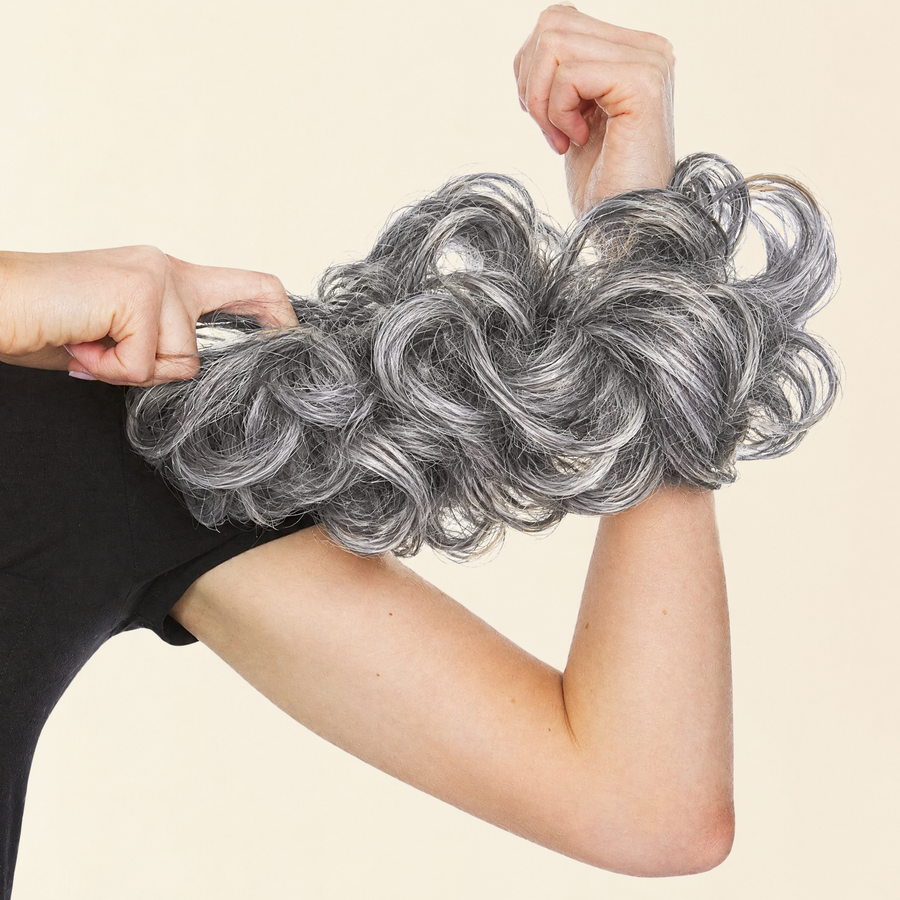 Hands stretching the JuvaBun Messy Bun in Salt And Pepper to show the scrunchie band