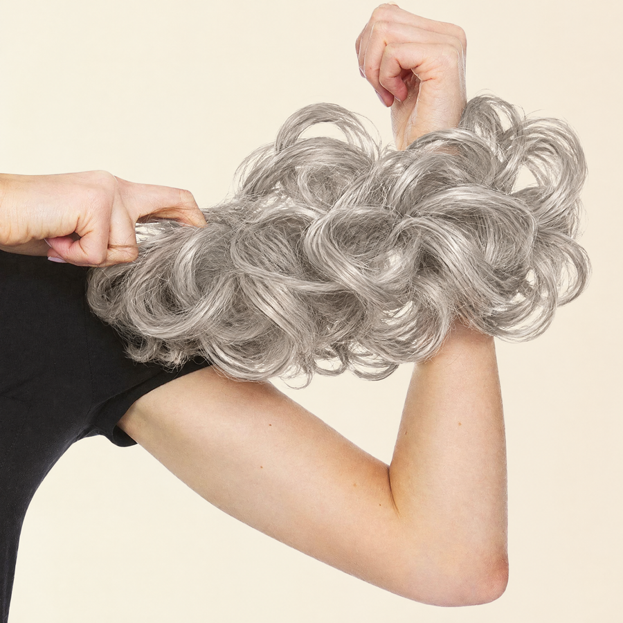 Hands stretching the JuvaBun Messy Bun in Silver Gray to show the scrunchie band