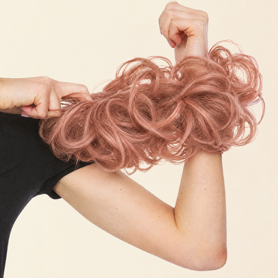 Hands stretching the JuvaBun Messy Bun in Soft Auburn to show the scrunchie band