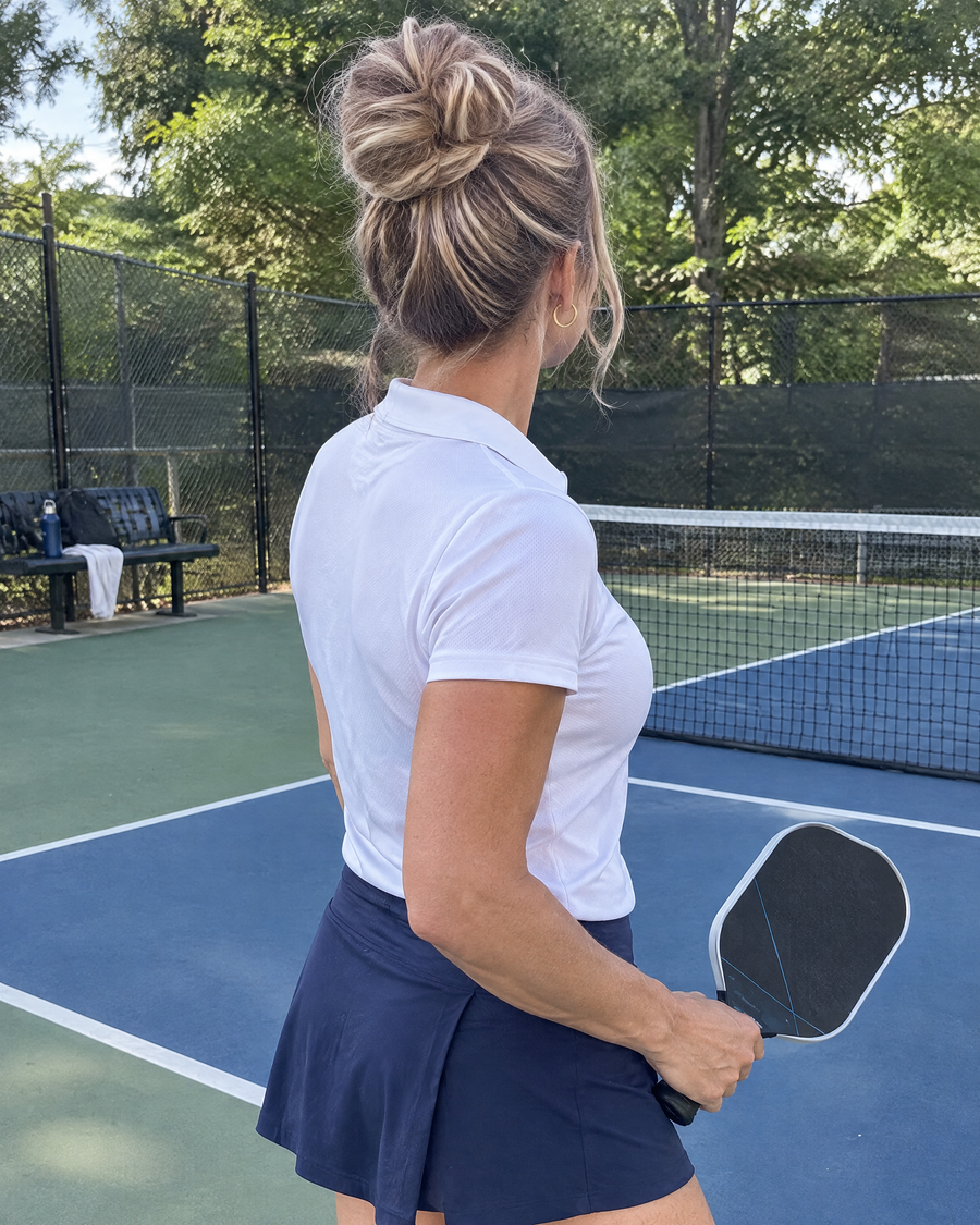 Woman wearing the JuvaBun Messy Bun in Strawberry Honey Blonde at the pickleball court