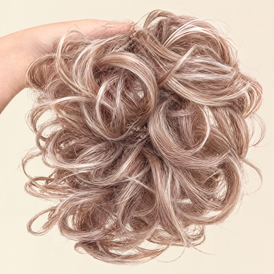 Hand holding the full JuvaBun Messy Bun in Strawberry Honey Blonde