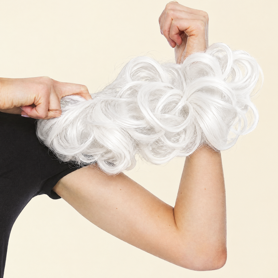 Hands stretching the JuvaBun Messy Bun in White to show the scrunchie band