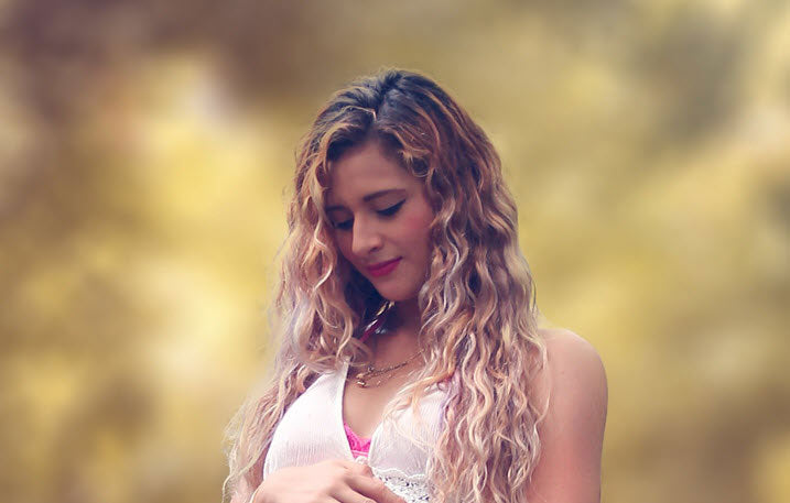 woman with curly long hair at the forest