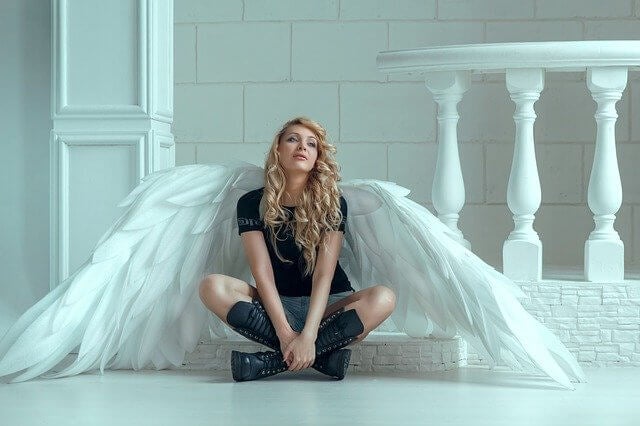 woman with angel wings sitting at the porch