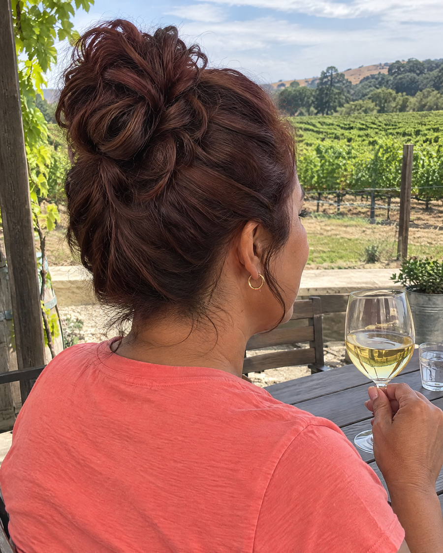 Woman wearing the JuvaBun Messy Bun in Auburn at a winery
