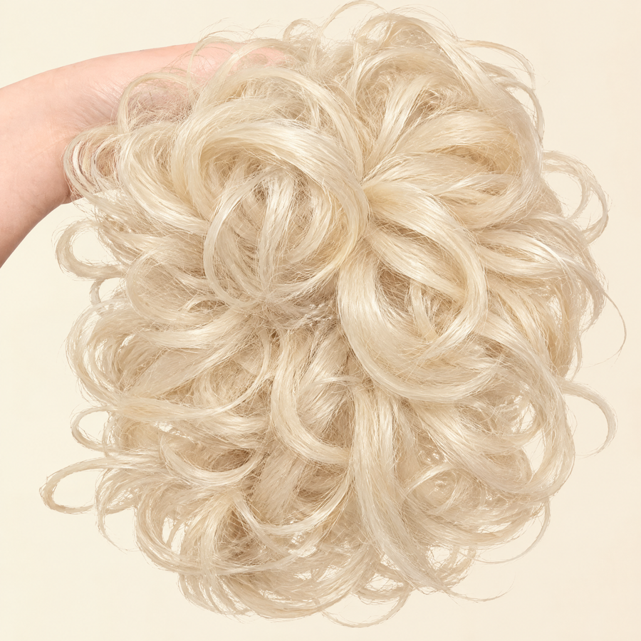 Hand holding the full JuvaBun Messy Bun in Platinum Blonde