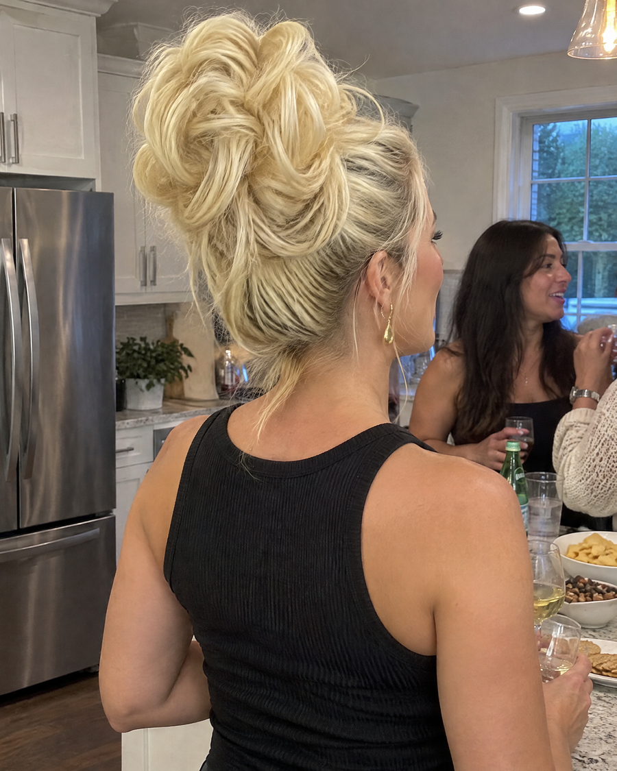 Woman wearing the JuvaBun Messy Bun in Pure Blonde at a house party