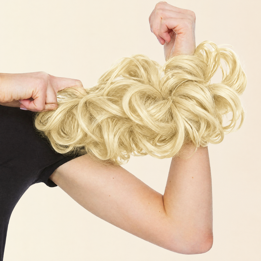Hands stretching the JuvaBun Messy Bun in Pure Blonde to show the scrunchie band