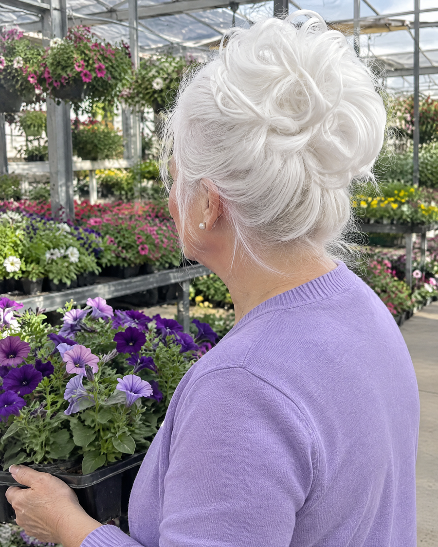 Woman wearing the JuvaBun Messy Bun in White at a garden center