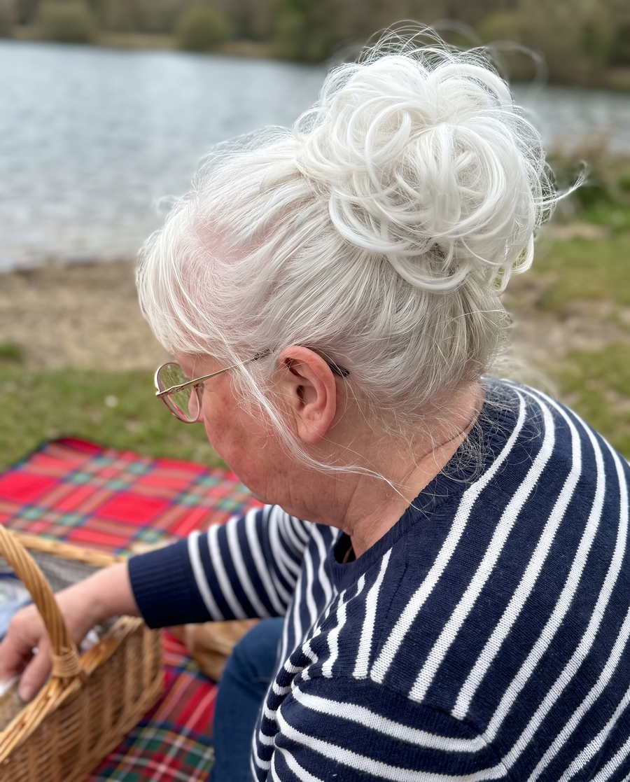 Woman wearing the JuvaBun Messy Bun in White at a lakeside picnic